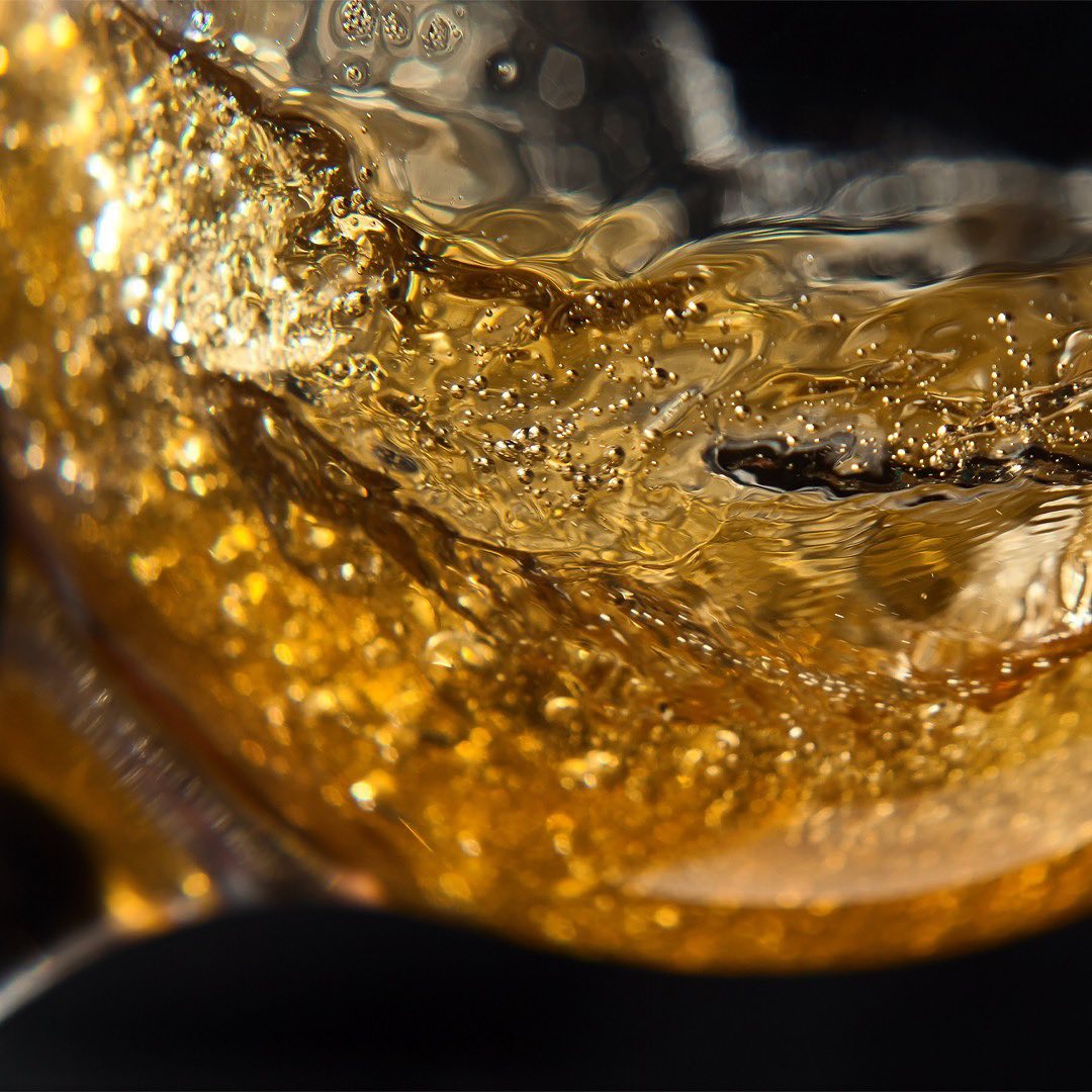 Makroaufnahme des MAEMO Glueh Gins mit feinen Blasen und lebendiger Bewegung im Glas